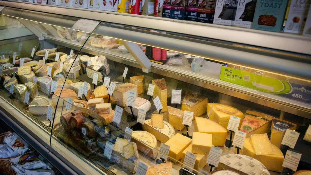 Wedges of cheese under glass at the deli counter