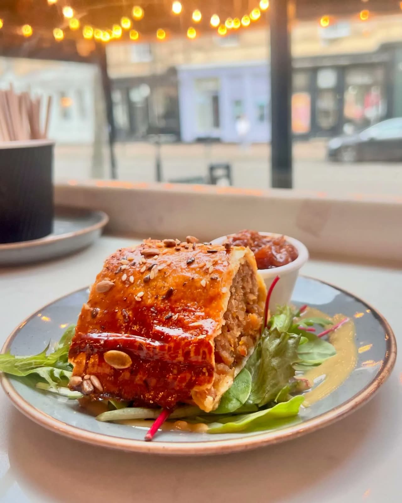 An apricot, sage and onion sausage roll with salad and chutney