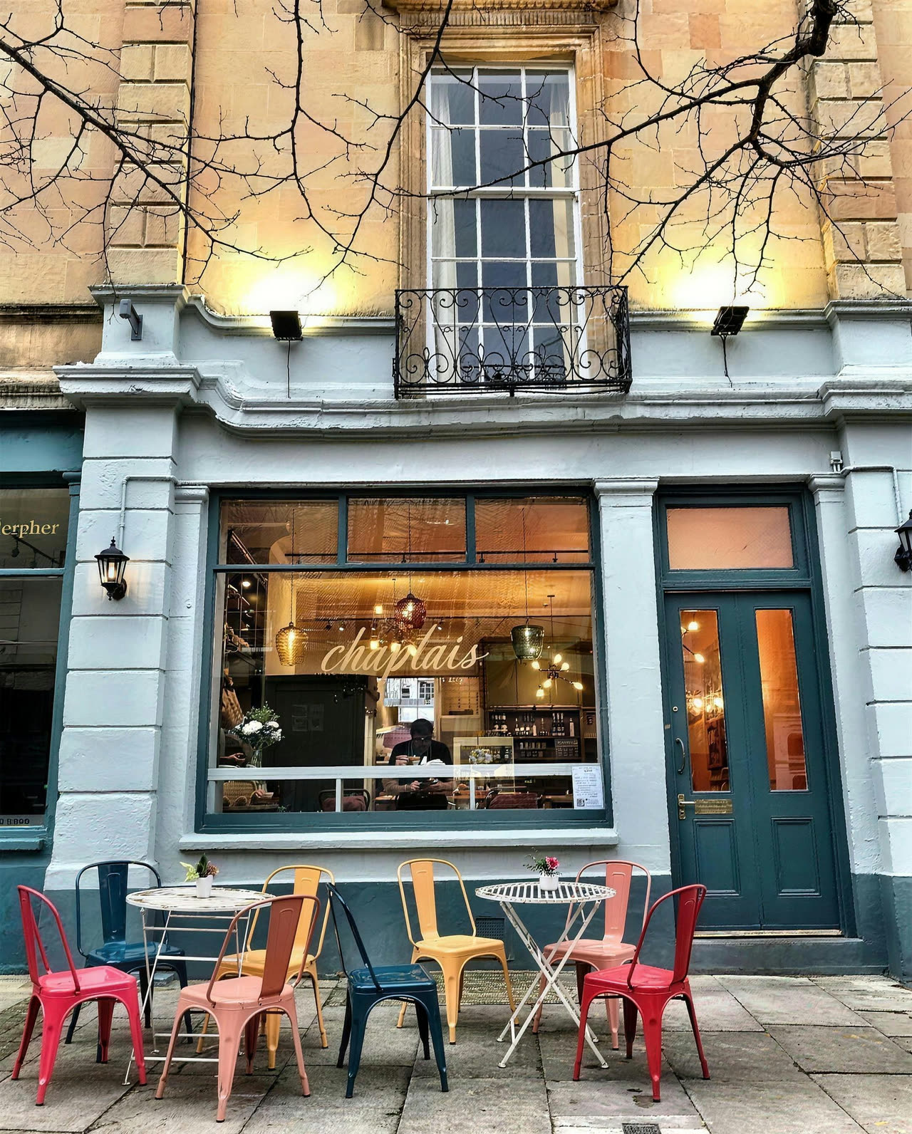The pale blue shopfront of Chaplais Kitchen on Rotunda Terrace, gold lettering on the window and colourful metal chairs outside